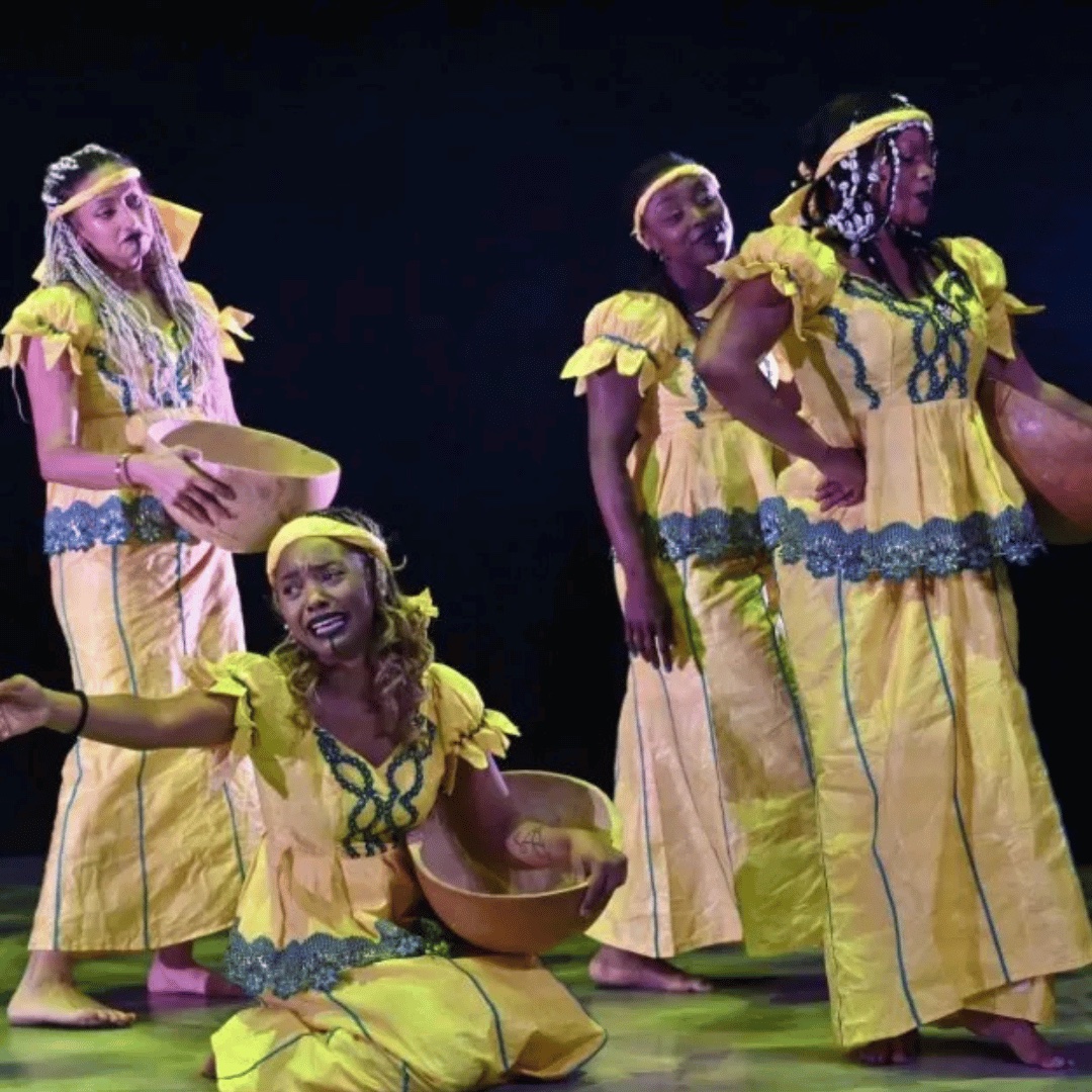 Danseuses du Ballet de la Diaspora Camerounaise en robes jaunes sur scène, calebasses à la main